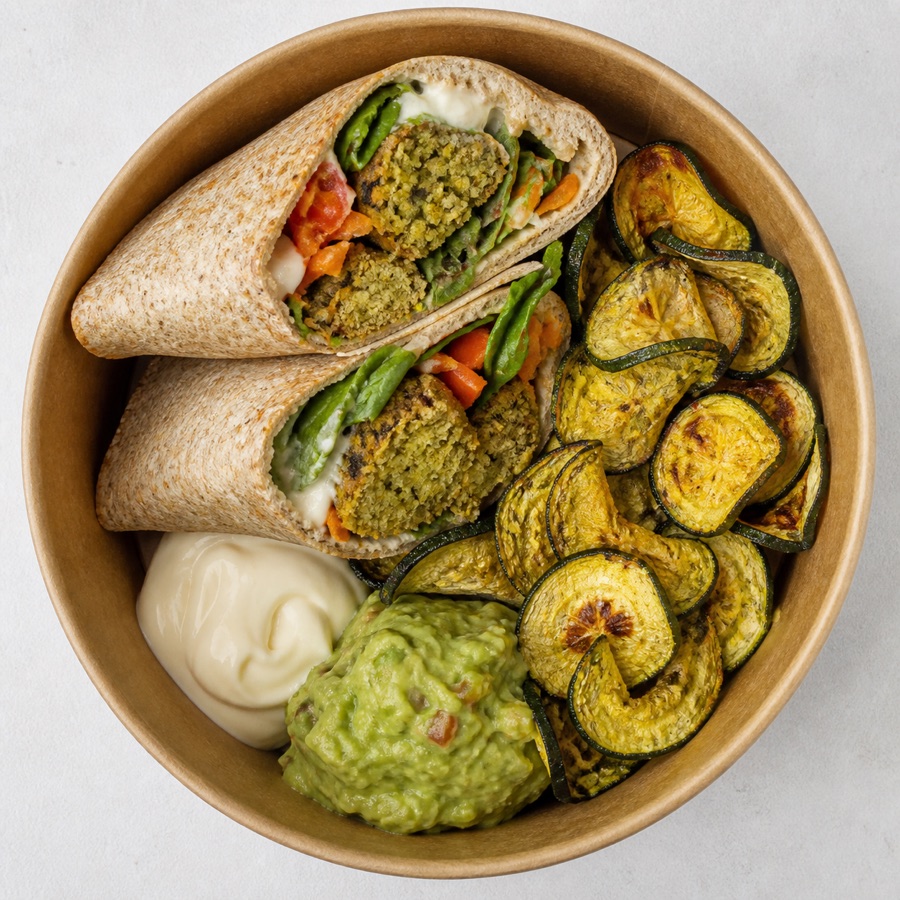 Vista cenital de Fajita de falafel y vegetales con mayo vegana, guacamole y chips de zucchini